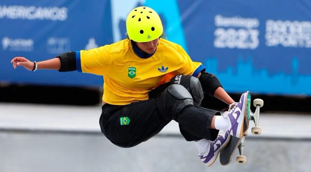 Atleta con casco giallo durante una manovra aerea sullo skateboard in una competizione internazionale