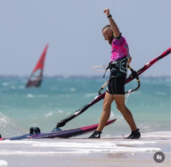 Windsurfer con tavola e vela vicino alla riva
