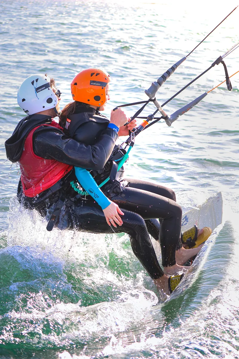 Istruttore e allievo di kitesurf durante un esercizio in acqua