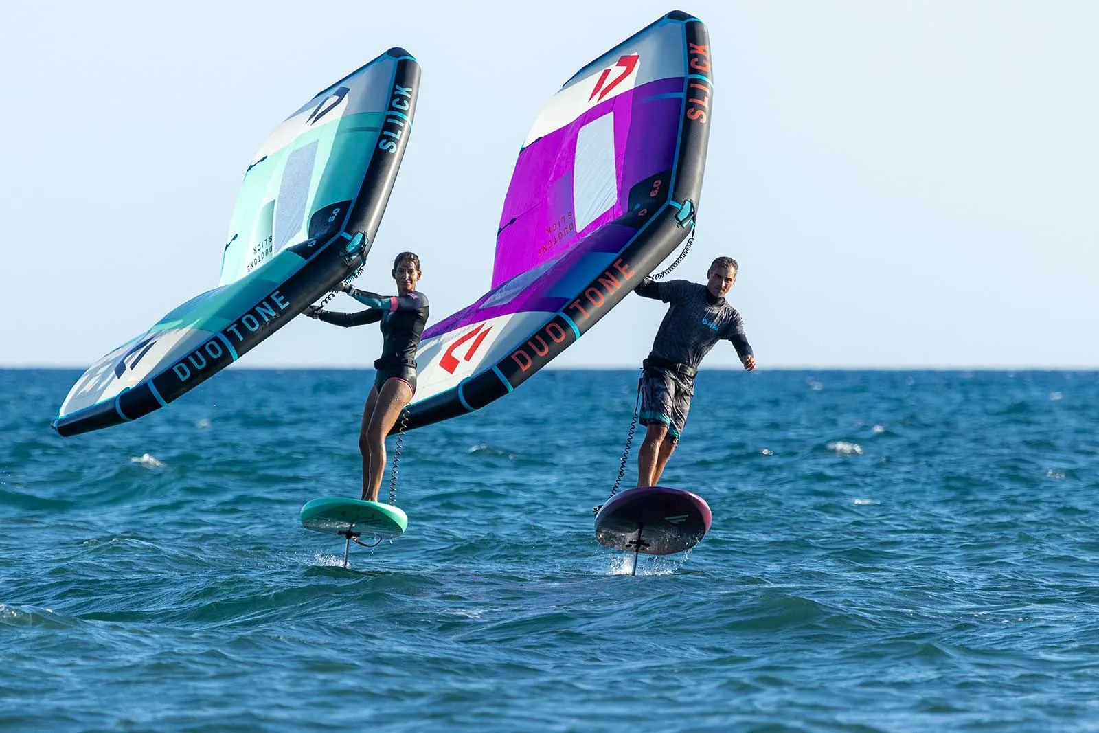 Due praticanti di wingfoil con wing e hydrofoil in mare