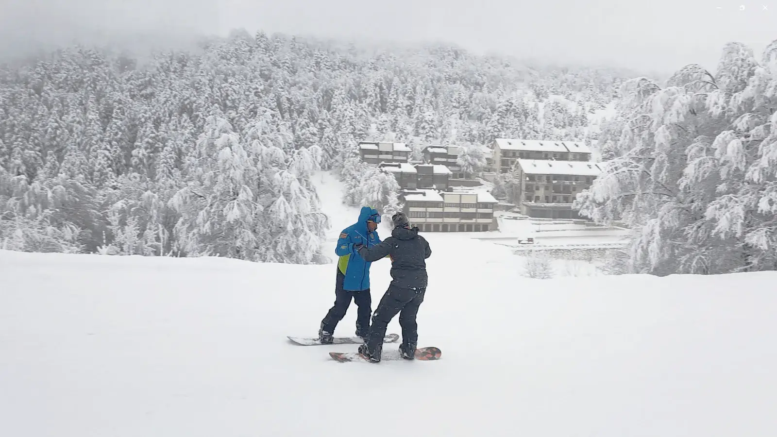 Maestro Federale di Snowboard con divisa nazionale blu mostra un dettaglio della tavola a un praticante sulla neve